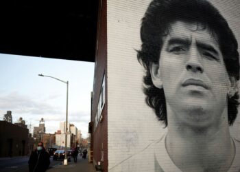 FILE PHOTO: A man walks past a mural depicting late Argentine football legend Diego Maradona in New York City, New York, U.S. March 28, 2023. REUTERS/Amanda Perobelli/File Photo