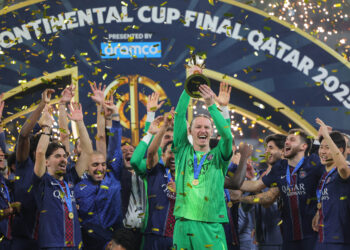 PSG's players celebrate on the podium after winning the 2025 FIFA Intercontinental Cup final football match between Paris Saint-Germain (PSG) and CR Flamengo at the Ahmad bin Ali Stadium in Al-Rayyan on the outskirts of Doha on December 17, 2025. (Photo by Karim JAAFAR / AFP)
